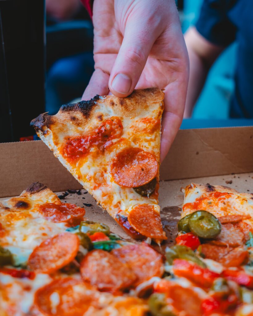 A slice of pizza being lifted at Pi Pizza Derry